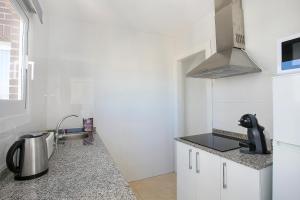 cocina con paredes blancas y encimera en Apartamentos Buenos Aires By Mc, en Benidorm