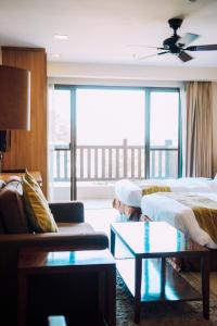 um quarto de hotel com duas camas e um sofá em Azalea Residences Baguio em Baguio mais 33 fotografias