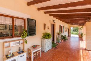 a living room with a red tile floor and wooden ceilings at La Coma in Pollença