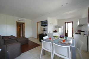 a kitchen and living room with a table and chairs at VILLA DELFINI 2-12 Pax in San Vito lo Capo