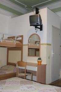 1 dormitorio con 1 cama, escritorio y TV en Hotel Ornella, en Lido di Camaiore