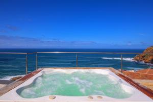 a hot tub with a view of the ocean at Alexander Guest House in Knysna