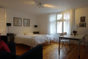 1 dormitorio con cama, mesa y ventana en Villa Elisabeth Apartments, en Pärnu