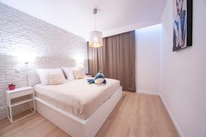 a white bedroom with a white brick wall at FEWO Sea View Porta Mare in Dziwnówek