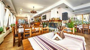 a restaurant with tables and chairs and a fireplace at Family Complex KrisBo in Donkovtsi
