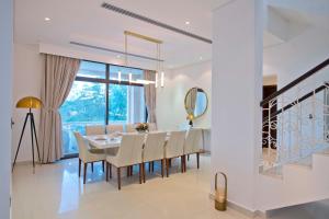 a dining room with a table and chairs and a window at Dibba, Villa 61 - Mina Al Fajer, Dibba Al Fujairah in Rūl Ḑadnā