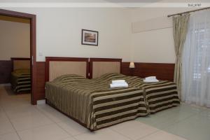 ein Schlafzimmer mit einem Bett mit zwei Handtüchern darauf in der Unterkunft Penzion RAKI in Bratislava