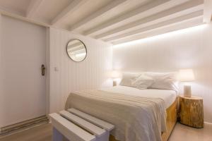 - une chambre blanche avec un lit et un miroir dans l'établissement Soul of Lisbon - I, à Lisbonne