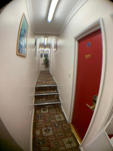 a hallway with a red door and stairs at Barking Hotel in Barking