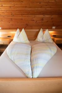 a bed with two pillows on top of it at Haus Pfalzen - Casa Falzes in Falzes