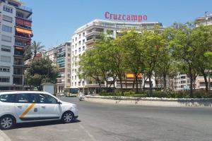 biały samochód zaparkowany na parkingu przed budynkiem w obiekcie BONITO APARTAMENTO TRIANA-LOS REMEDIOS w Sewilli
