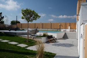 a pool with a bench and a tree in a yard at The Pines Boutique Villa - Vama Veche in Vama Veche