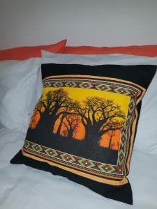 a pillow with a tree on a bed at Lyronne Guest house, Shuttle and Tours in Cape Town