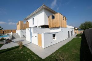 a white house with wooden boxes on top of it at The Pines Boutique Villa - Vama Veche in Vama Veche