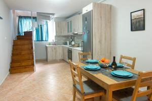 eine Küche und ein Esszimmer mit einem Holztisch und Stühlen in der Unterkunft Loft renovated flat 5' from the old town Corfu in Korfu-Stadt