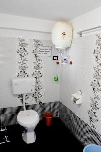 a bathroom with a toilet and flowers on the wall at Bansi Niwas in Udaipur