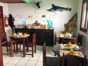 a dining room with two tables and a fish on the wall at Pousada Tranquila in Morro de São Paulo