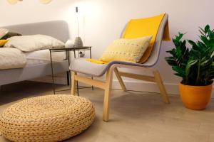 a chair and a stool in a room with a bed at STUDIO ELA Centre in Košice