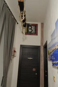 ナポリにあるBHome Fashion Suiteの扇風機付きの部屋の扉の上にぶら下がっている看板