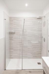 a shower with a glass door in a bathroom at Miravallesuites in San Zeno di Montagna