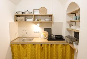 a kitchen with a sink and a yellow curtain at STUDIO ELA Centre in Košice