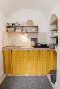 a kitchen with a yellow counter with a sink at STUDIO ELA Centre in Košice