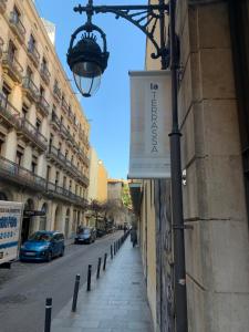 een straat met een bord aan de zijkant van een gebouw bij La Terrassa in Barcelona