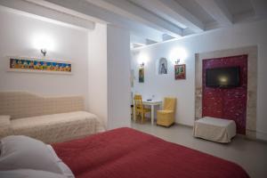 a bedroom with a bed and a tv and a table at Aretusa Vacanze B&B in Siracusa