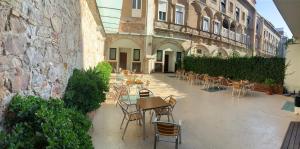 un patio extérieur avec des chaises et des tables ainsi qu'un bâtiment dans l'établissement Hostal La Terrassa, à Barcelone