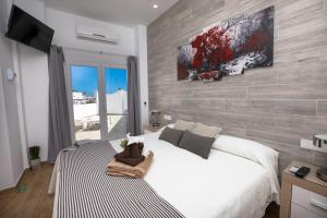 a bedroom with a white bed and a wall at Hostal Casa Mercedes in Nerja