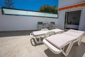 two beds sitting on a patio next to a building at Hostal Casa Mercedes in Nerja