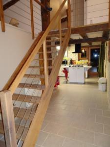 a staircase in a house with a kitchen in the background at Domaine du Clos de la Touche Parc et Piscine in Chaunay