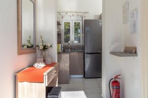 a kitchen with a refrigerator and a counter with a table at Sweet Home Kremasti in Kremasti