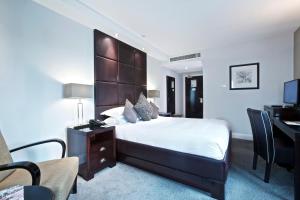 a bedroom with a bed and a desk at Millennium & Copthorne Hotels at Chelsea Football Club in London