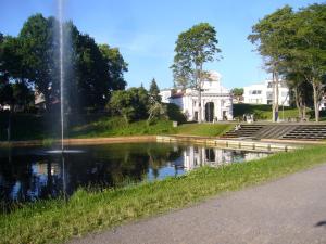 a fountain in a park with a building in the background at Villa Elisabeth Apartments in Pärnu