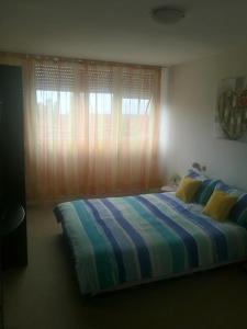 1 dormitorio con cama de rayas y ventana en APARTMENT SUNSHINE- center of Split, en Split