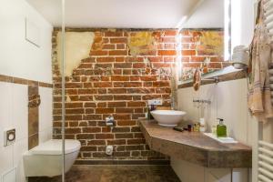 a bathroom with a sink and a brick wall at Romantik Hotel Scheelehof Stralsund in Stralsund