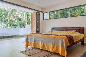 um quarto com uma cama e uma grande janela em StayVista at Davey's Townhouse with Breakfast & Pet Friendly Home em Mysore