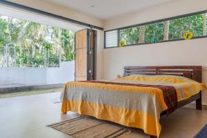 a bedroom with a bed and a large window at StayVista at Davey's Townhouse with Breakfast & Pet Friendly Home in Mysore