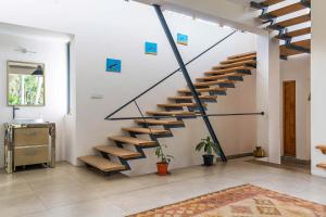 a staircase in a living room with wooden steps at Spacious 3BR Daveys Townhouse with Private Lawn Pet Friendly and Complimentary Breakfast in Mysore +20 photos
