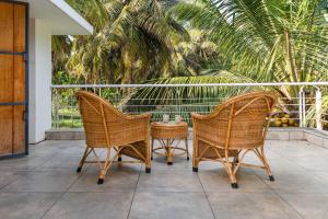 two wicker chairs and a table on a patio at Spacious 3BR Daveys Townhouse with Private Lawn Pet Friendly and Complimentary Breakfast in Mysore