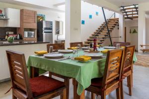 a dining room with a table with a green table cloth at Spacious 3BR Daveys Townhouse with Private Lawn Pet Friendly and Complimentary Breakfast in Mysore