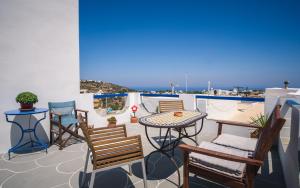 een patio met stoelen en een tafel op een balkon bij GIAMAKI APARTMENTS in Sifnos