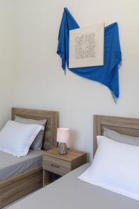 una camera con 2 letti con lenzuola blu e una lampada di Sweet Home Kremasti a Kremasti