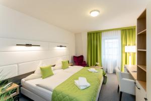 a hotel room with a bed and a desk at Hotel Stadtfeld in Magdeburg