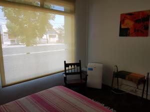 1 dormitorio con cama, ventana y radiador en GLAMAUÉ en Carhué