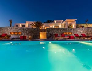 a villa with a swimming pool at night at O Lofos Luxury Boutique Suites in Agios Stefanos