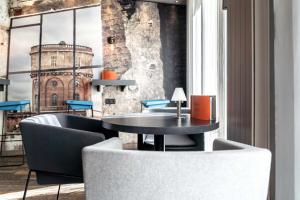 a table and chairs in a room with a window at Altstadthotel in Ingolstadt