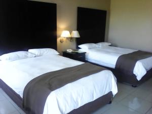 um quarto de hotel com duas camas e duas lâmpadas em Wilderness Beach Hotel em Wilderness