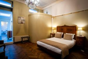 
a hotel room with a bed, chair, and nightstand at Charme Hotel Hancelot in Ghent
